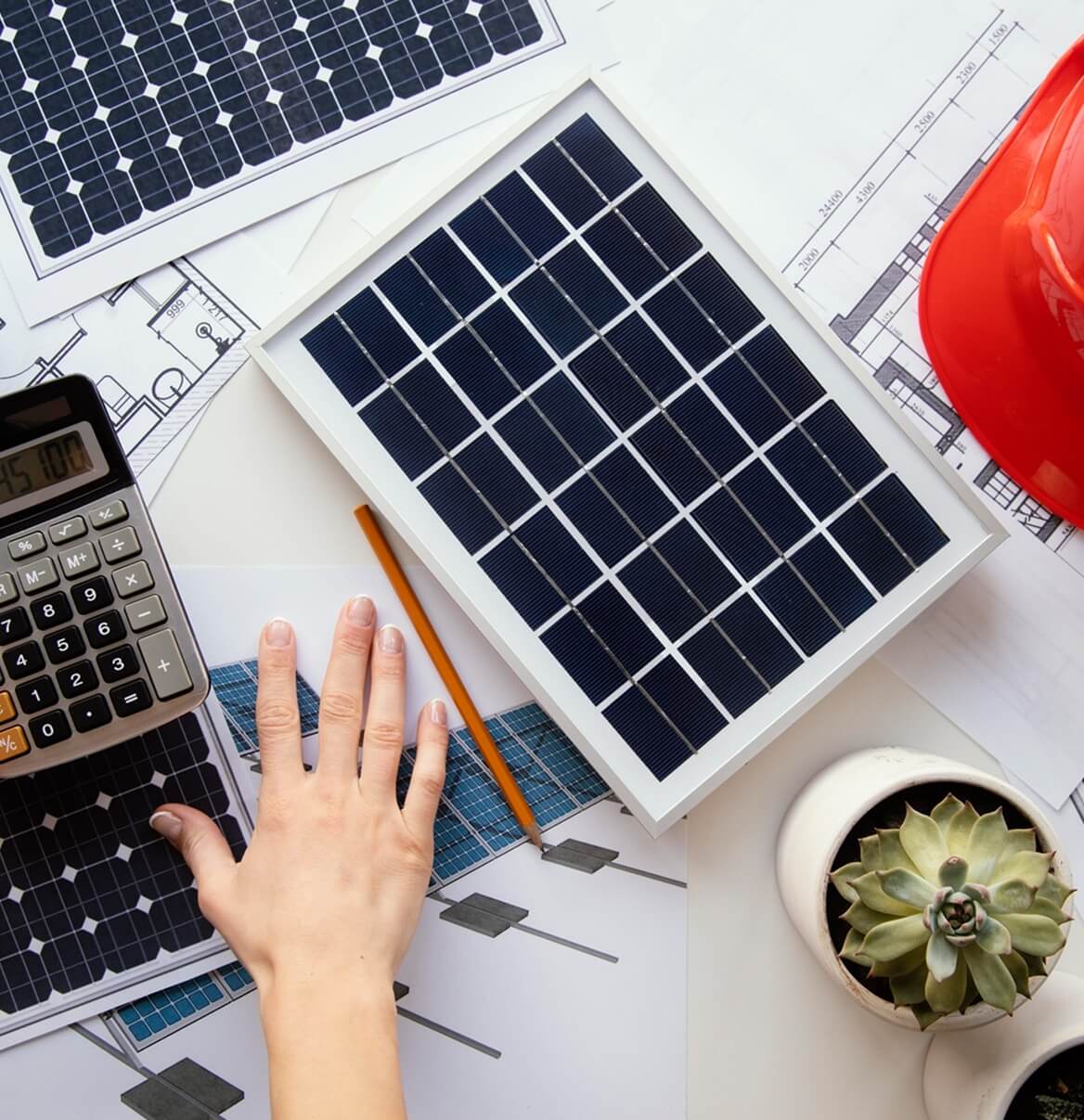 Schreibtisch-Draufsicht mit Solarmodul, Taschenrechner und Bauplan für PV-Berechnung