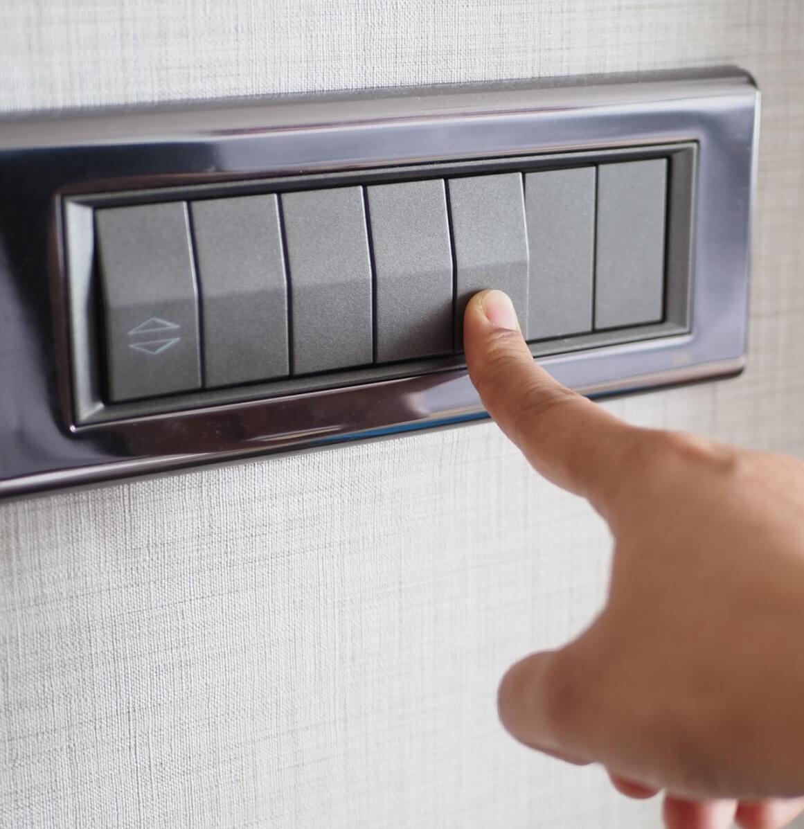 Elektriker öffnet Außenverteiler an Betriebsgebäude für Elektroprüfung